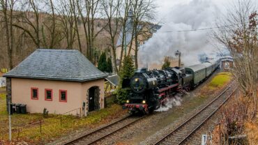 52 8154 passiert mit dem Museumszug den Bahnhof Hartenstein. Die Lok ist mit Fichtenzweigen geschmückt und machte eine große Dampffahne.
