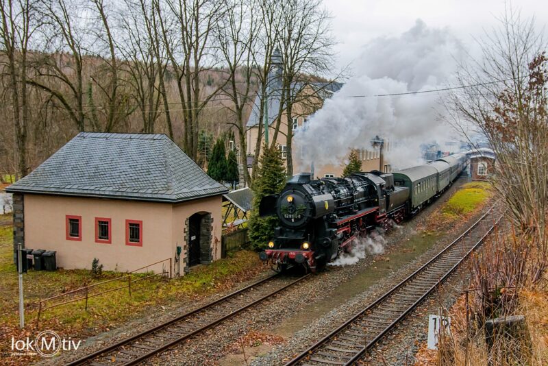 52 8154 passiert mit dem Museumszug den Bahnhof Hartenstein. Die Lok ist mit Fichtenzweigen geschmückt und machte eine große Dampffahne.