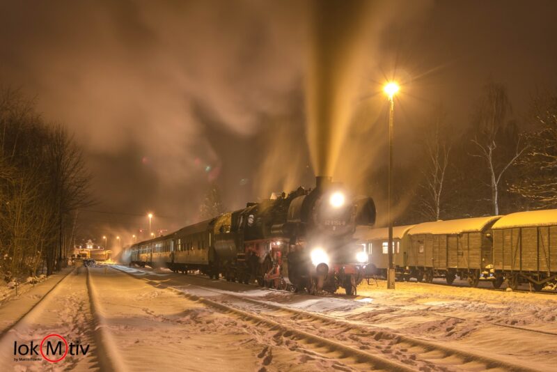 52 8154 mit großer Dampfsäule im tief verschneiten Schlettauer Bahnhof.