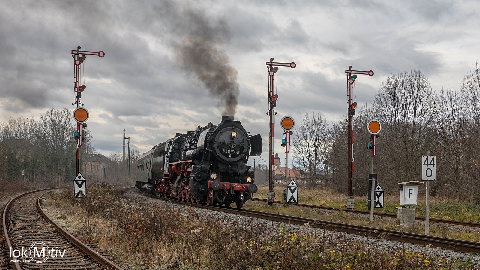 Dampfbahnmuseum Leipzig 52 8154 zwischen den Einfahrtssignalen in Zeitz. Das Wetter ist wolkig.