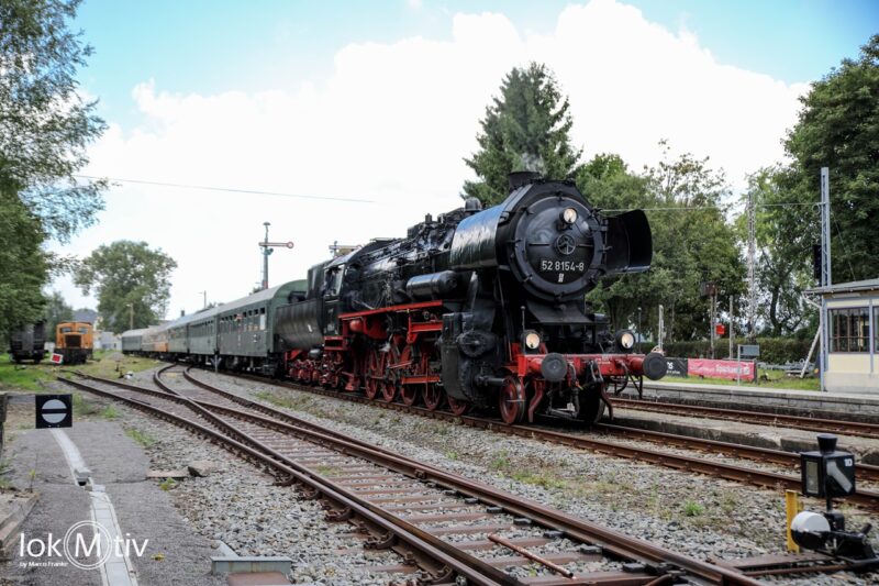 Sie sollten sehen: die Dampflokomotive 52 8154 mit dem Museumszug des Eisenbahnmuseums Leipzig bei der Einfahrt in Schlettau. Links im Bild steht eine orange Rangierlok der Baureihe V15.