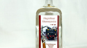 Sie sollten sehen: eine Flasche mit klaren Schnaps. Auf dem Etikett ist die Lokomotive 51 8154 mit Blick auf den Tender bei der Wasserbefüllung zu sehen.