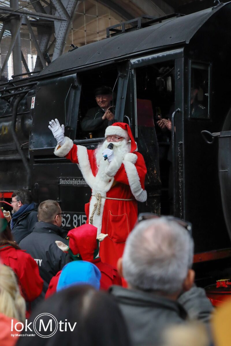 Das Bild zeigt den Weihnachtsmann beim Absteigen von der Dampflok des Leipziger Eisenbahnmuseums.