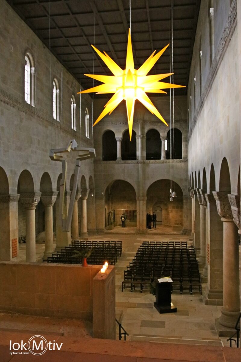 Blick in die Kirche des Doms zu Quedlinburg mit leuchtendem gelben Stern.