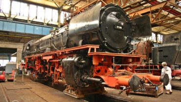 Eine ausgeachste auf Hilfsgestellen stehende Tenderlokomotive der Baureihe 01 (Bundesbahn).