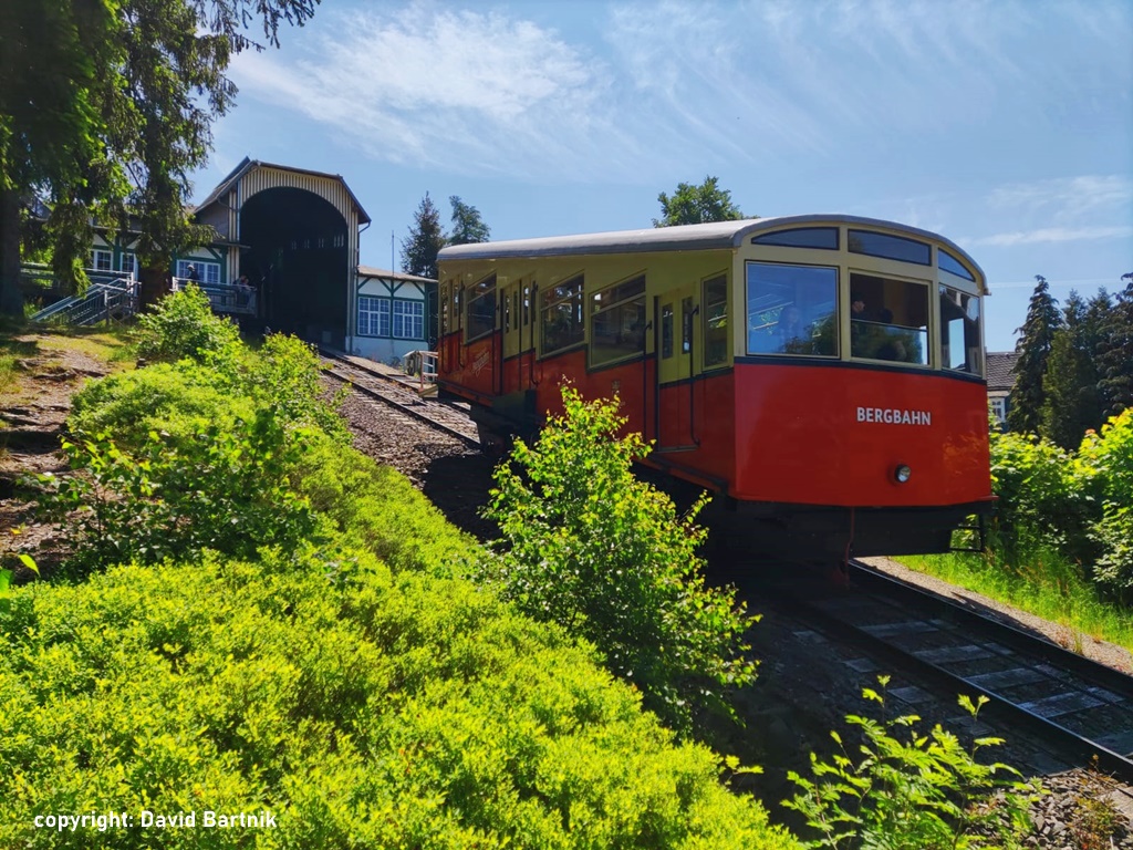 Das Bild zeigt einen der überdurchschnittlichen Steigung der Bergbahn angepassten Personenwagen vor dem Einfahrtsportal der Bergstation.