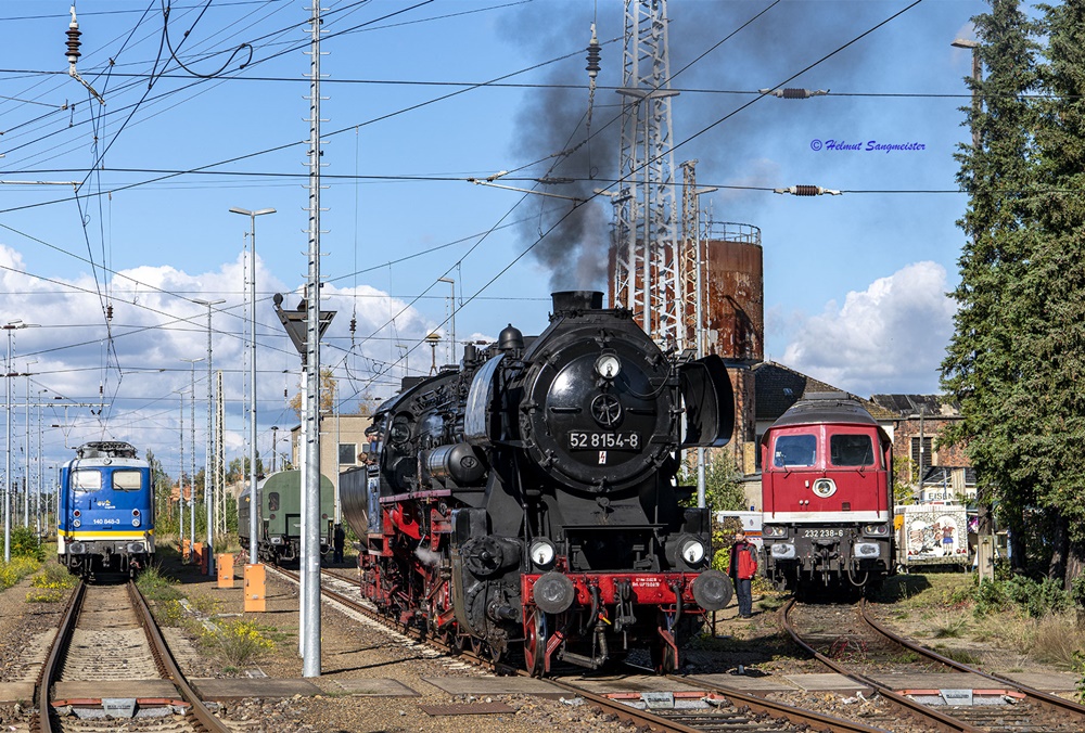 Das Bild zeigt den Blick in die Anschlussbahn des Museums in Falkenberg. Ganz links ist eine E-Lok der Baureihe140 - ehemals Bundesbahn - zu sehen, während 52 8154 des Eisenbahnmuseums Leipzig auf Fahrtfreigabe wartet. Im Abstellgleis rechts steht 232 238.