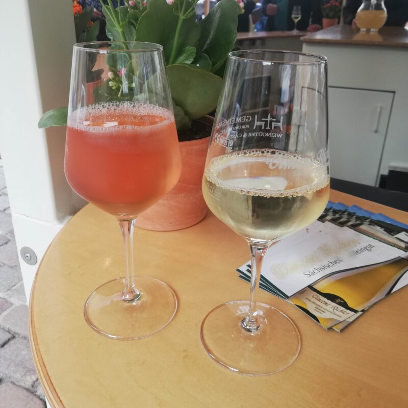Zeigt zwei Gläser Wein, ein Glas Rosé und ein Glas Weißwein.