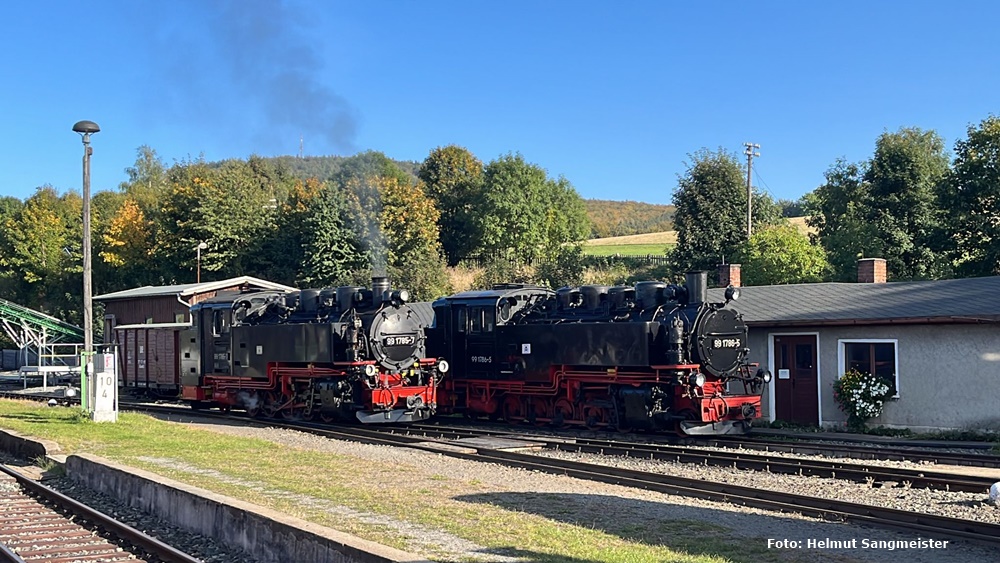 Das Bild zeigt zwei Dampflokomotiven der Fichtelbergbahn im Bahnhof von Cranzahl. Die Lokomotiven stehen versetzt.