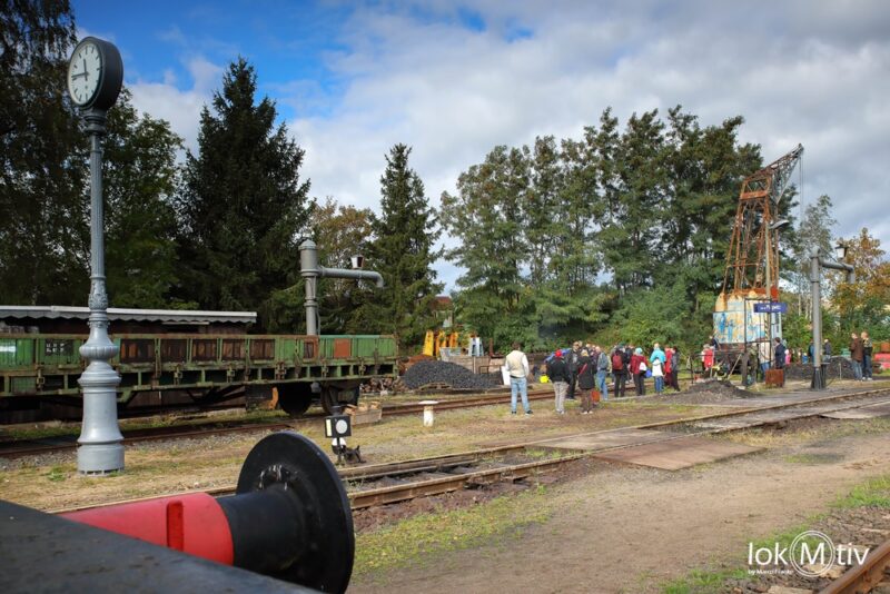 Zu sehen ist das Gelände des Museums über einen Puffer fotografiert mit der Säulenuhr links, einem Wasserkränen und dem Eisenbahndrehkran EDK80.