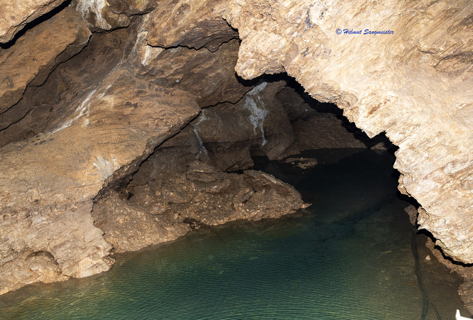 Zu sehen Ausschnitt eines unterirdischen Sees mit glasklarem Wasser umgeben und überspannt von einem Felsengewölbe.