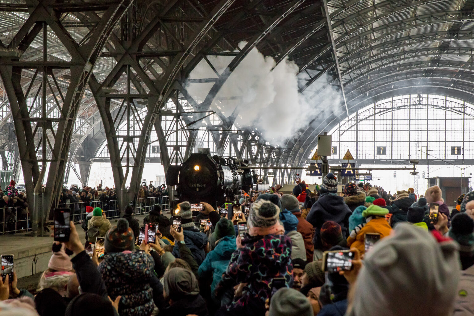 Das Bild zeigt 52 8154 in einer Menschenmenge im Hauptbahnhof Leipzig. Der Weihnachtsmann grüßt von der Lok herunter.