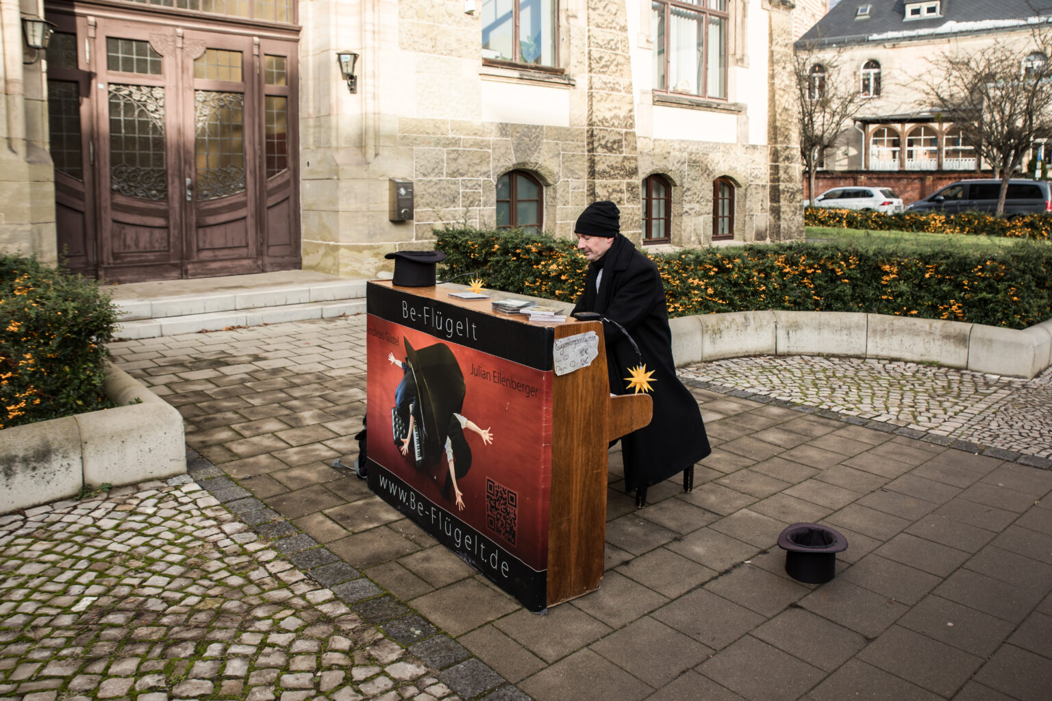 Ein Pianospieler samt Instrument beim Musizieren unter freiem Himmel.