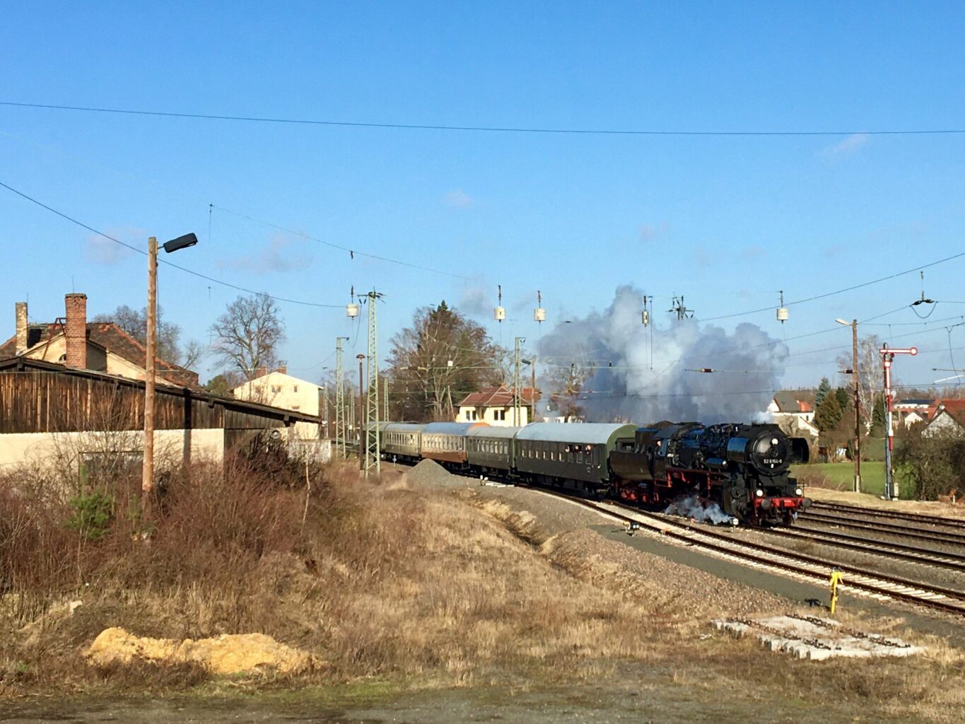 Da Bild zeigt unseren Dampflok bespannten Museumszug vor der alten Bahnhofskulisse von Regis Breitingen. Links alte Güterabfertigungshallen und rechts ein Formsignal.