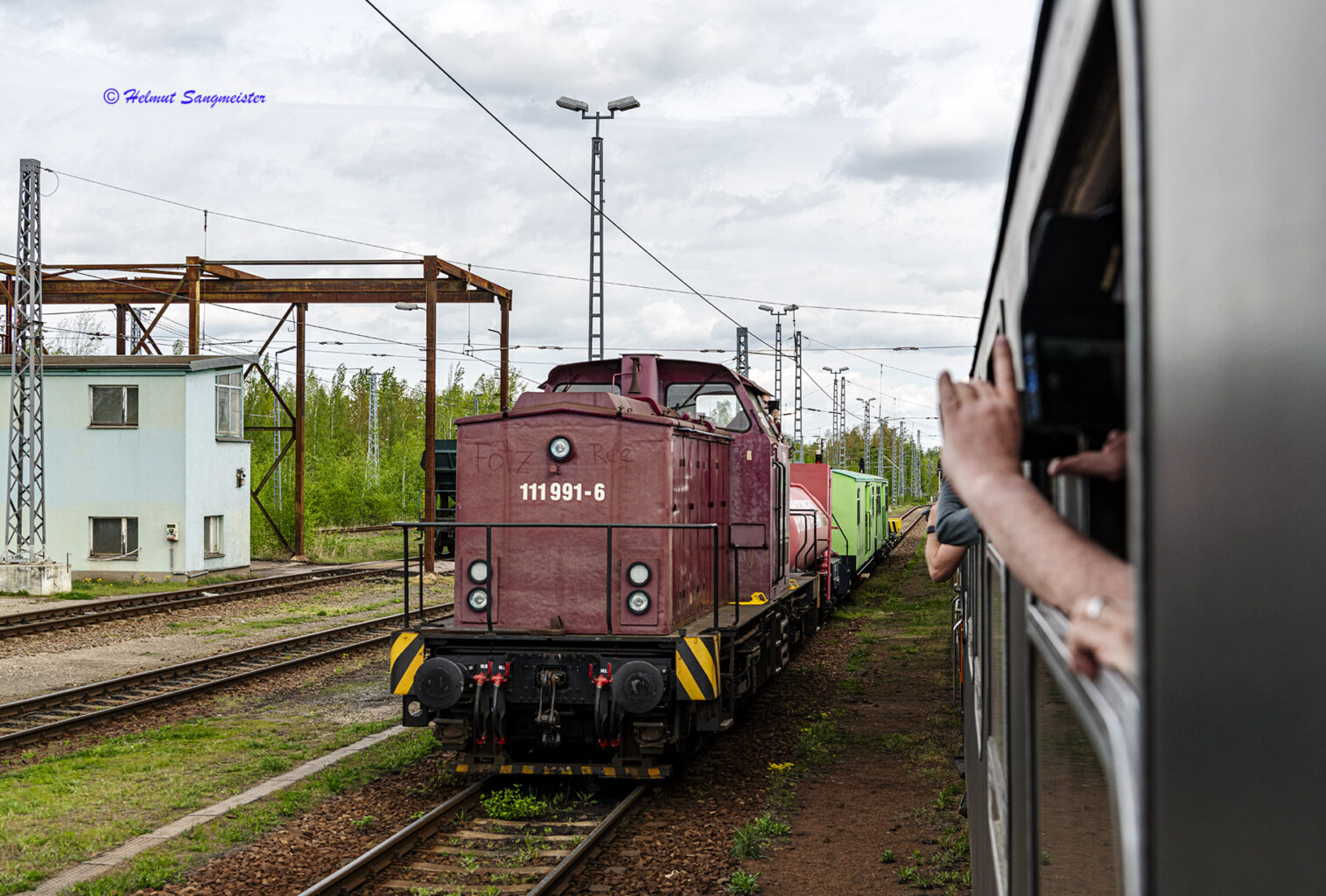 Eine V100 Nr. 111 991-6 passiert mit Hilfszug unseren Zug längs.