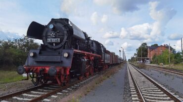 Dampflok 35 1097 mit Wagen neben einem Bahnhof